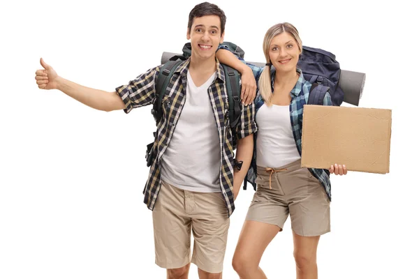 Hikers hitchhiking and holding a blank cardboard sign — Stock Photo, Image