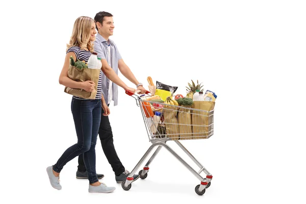 ショッピングカートを押す若いカップル — ストック写真