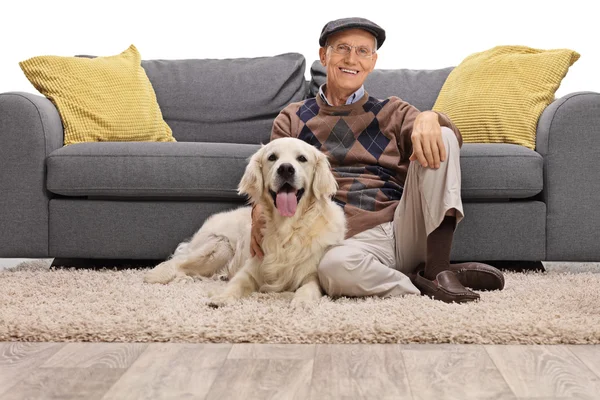 彼の犬と一緒に床に座っている中年の男性 — ストック写真