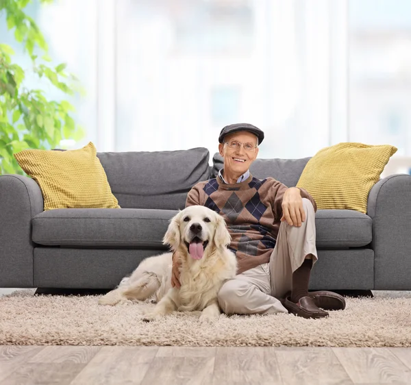 Starší muž, sedící na podlaze se svým psem — Stock fotografie