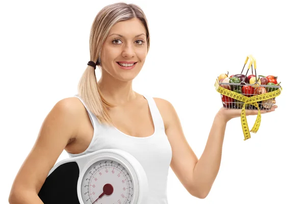 Vrouw met een winkelwagentje en een gewicht-schaal — Stockfoto