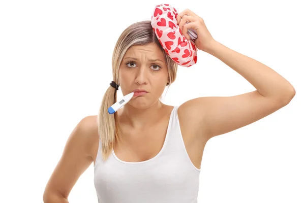 Mujer enferma sosteniendo un termómetro y una bolsa de hielo — Foto de Stock