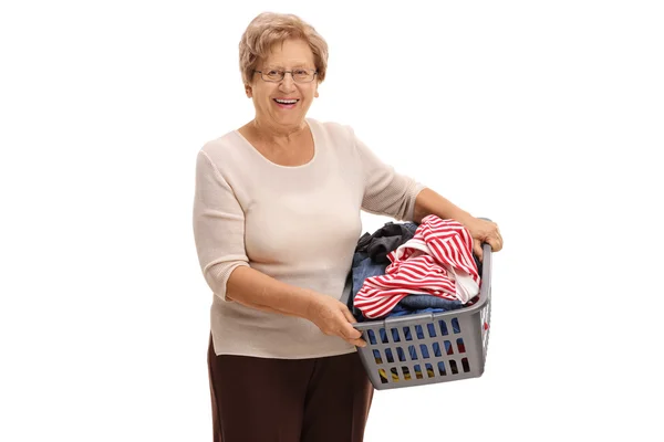 Donna matura che tiene un cesto della lavanderia — Foto Stock