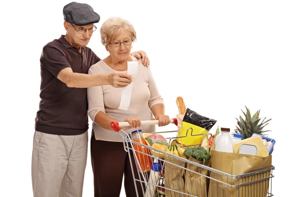 Geschokt bejaarde echtpaar kijken naar een winkel-ontvangst — Stockfoto