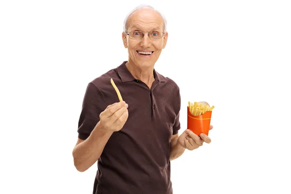 Senior sosteniendo una sola fritura y una bolsa de papas fritas — Foto de Stock