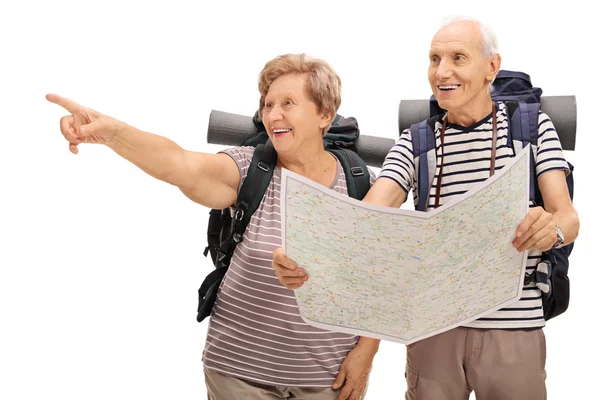 Hikers pointing at a landmark and holding a map — Stock Photo, Image