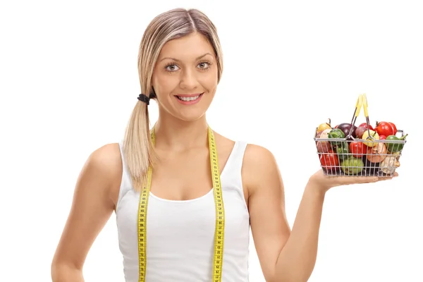 Chica posando con cinta métrica y pequeña cesta de la compra —  Fotos de Stock