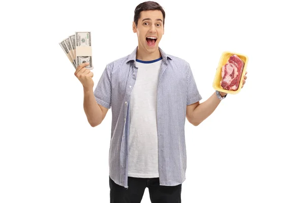 Hombre sosteniendo paquetes de dinero y un filete — Foto de Stock