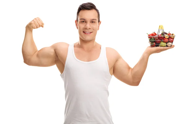 Man flexing his bicep and holding shopping basket — Stock Photo, Image