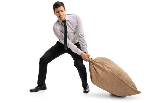Ung affärsman att dra en säckväv säck — Stockfoto