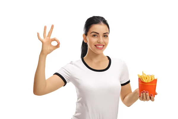 Donna in possesso di borsa di patatine fritte e fare gesto ok — Foto Stock