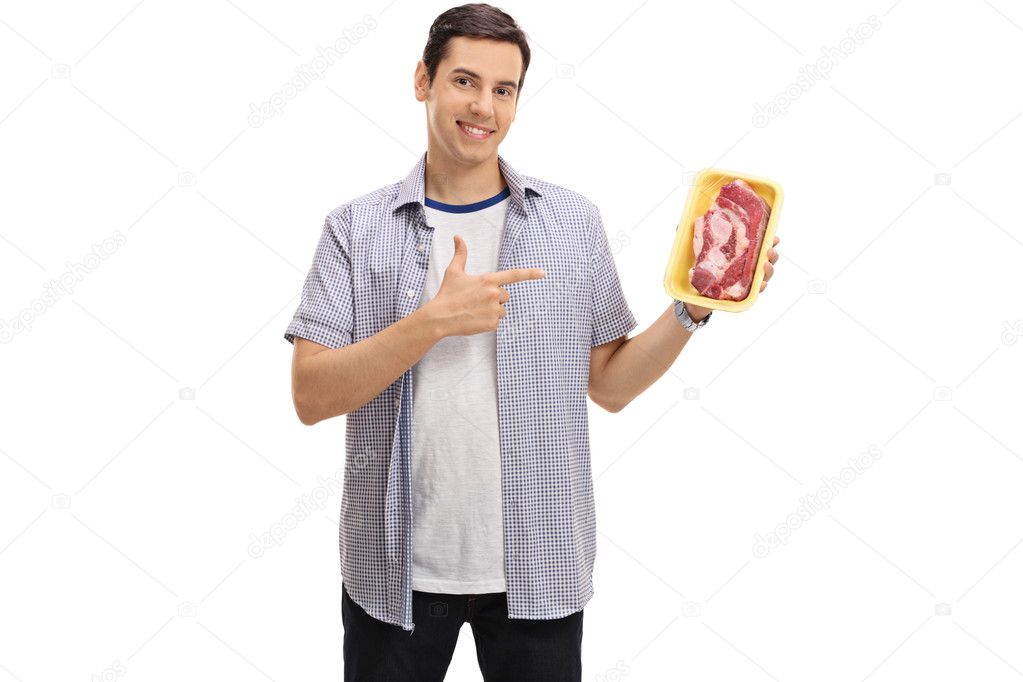 Cheerful guy holding a steak and pointing