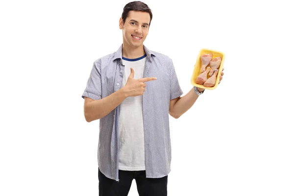 Man holding a pack of chicken drums and pointing — Stock Photo, Image