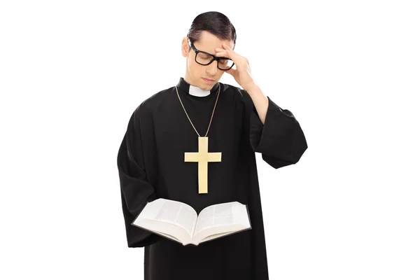 Trauriger junger Priester liest die Bibel — Stockfoto