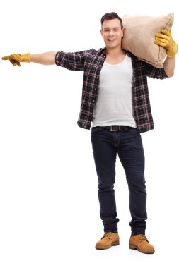 Bir çuvala tutarak ve işaret eden erkek çiftçi