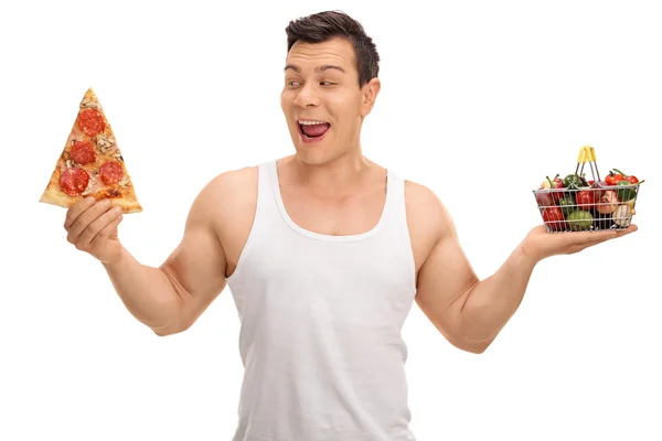 Ragazzo che tiene fetta di pizza e piccolo carrello della spesa — Foto Stock