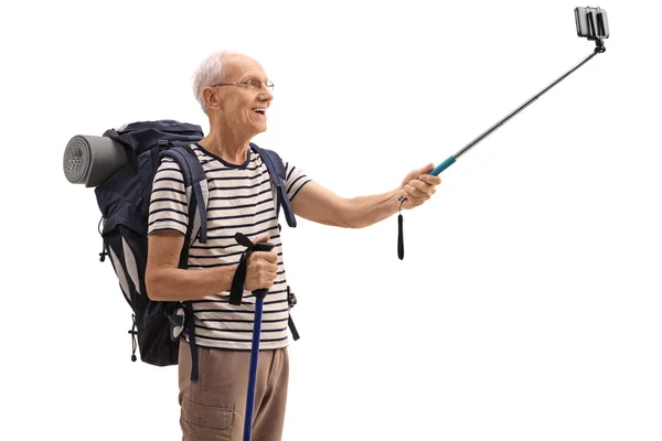 Elderly male hiker taking a selfie with a stick — Stock Photo, Image