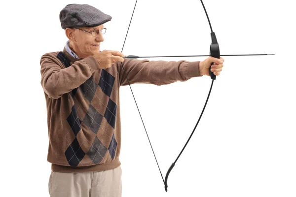 Elderly man aiming with a bow and arrow — Stock Photo, Image