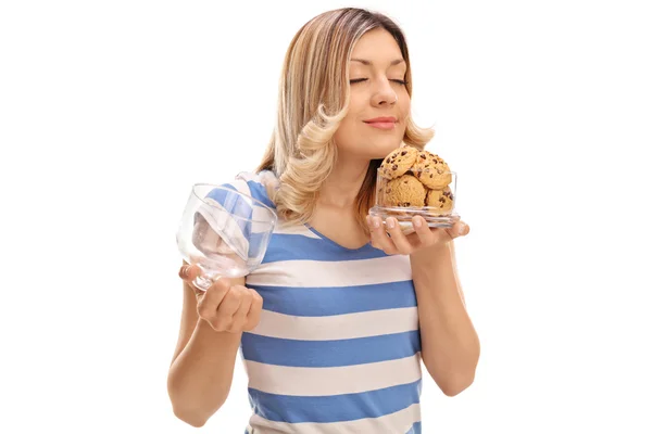 Mulher cheirando biscoitos em um frasco — Fotografia de Stock