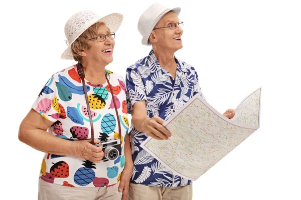 Туристы держат общую карту и смотрят вдалеке — стоковое фото