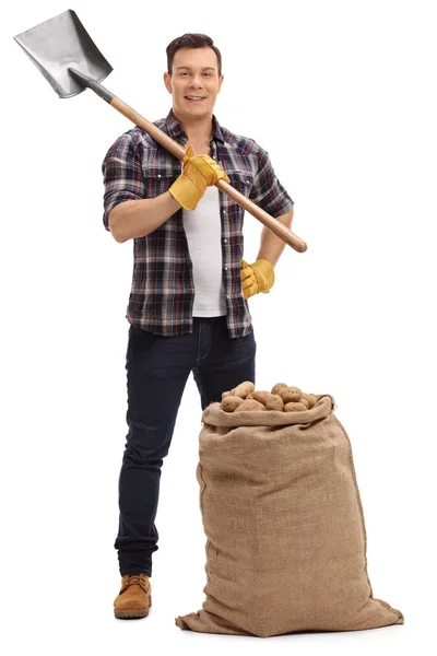 Male agricultural worker posing with shovel and burlap sack — Stock Photo, Image