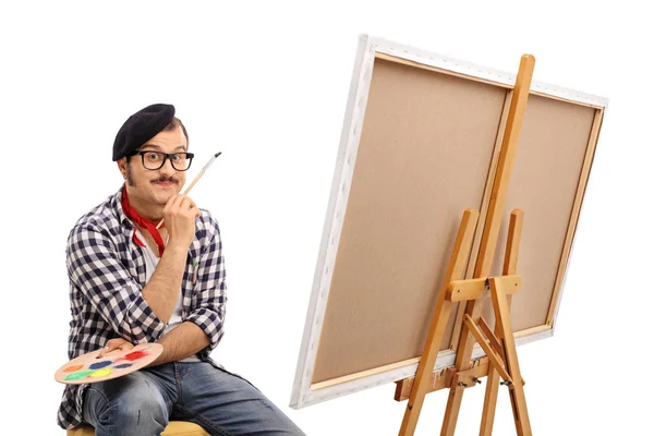 Painter posing next to a canvas and contemplating — Stock Photo, Image