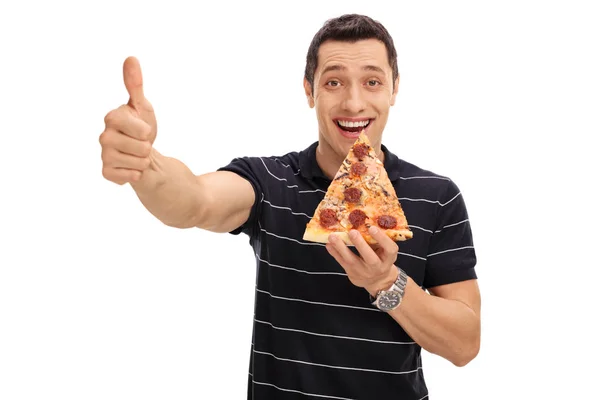 Homem comendo fatia de pizza e dando o polegar para cima — Fotografia de Stock