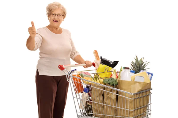 Ältere Dame mit Einkaufswagen gibt Daumen hoch — Stockfoto
