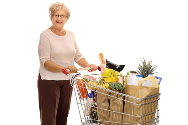 Senhora madura alegre com carrinho de compras — Fotografia de Stock