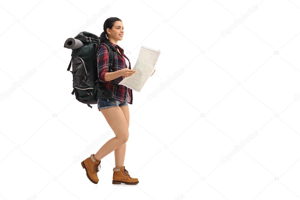 Female hiker walking and holding a generic map