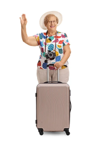 Cheerful mature tourist with a suitcase waving — Stock Photo, Image