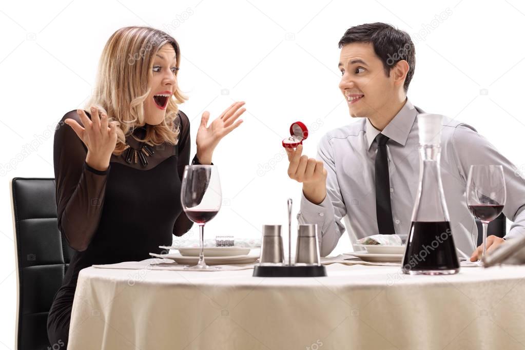 guy proposing to his girlfriend at a restaurant table