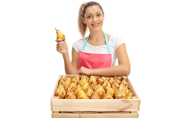 Vrouwelijke leverancier achter een krat vol met peren — Stockfoto