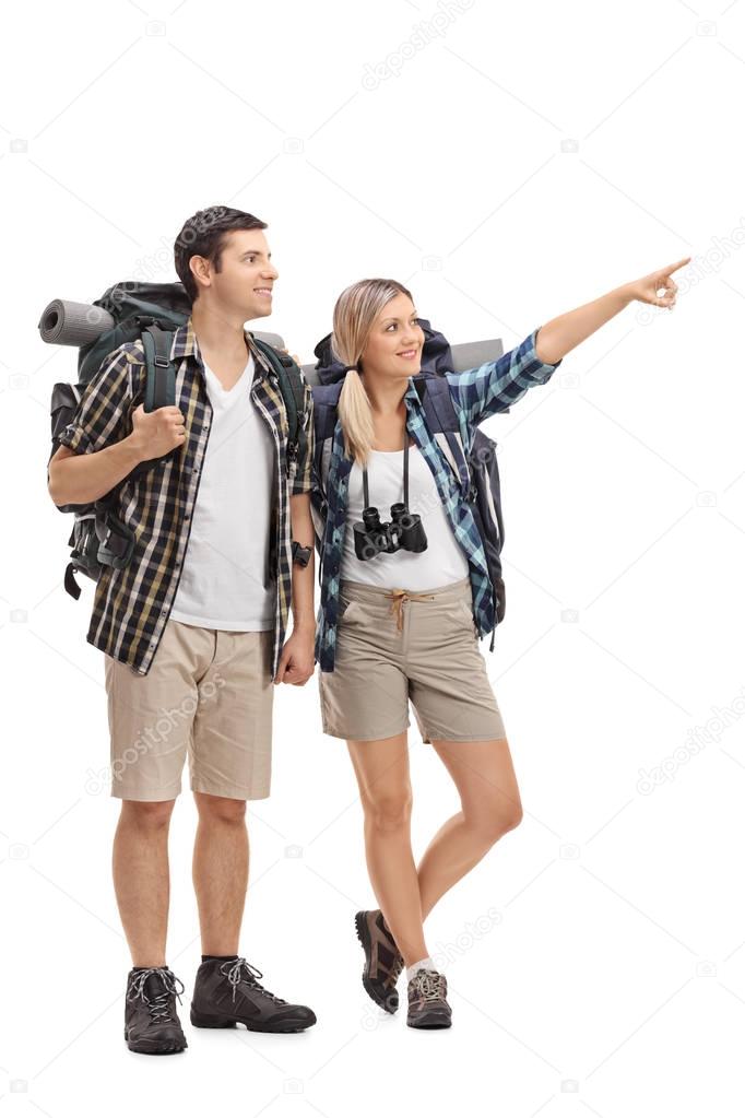 Female hiker showing something in the distance to a male hiker