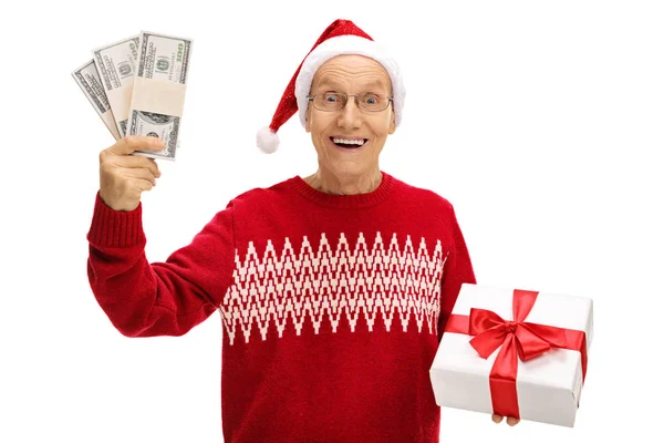 Gelukkig senior houden een kerstcadeau en bundels van geld — Stockfoto