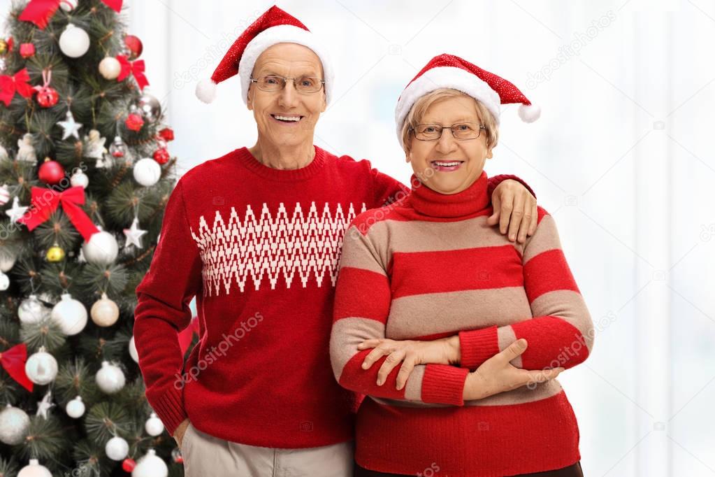 senior couple in front of a Christmas tree