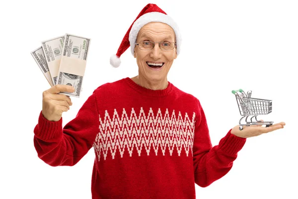 Senior drží peníze balíčky a malého nákupního košíku — Stock fotografie