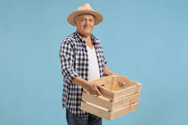 Bejaarde boer houden een houten krat — Stockfoto