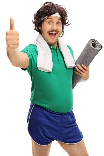 Retro sportsman holding an exercising mat and giving a thumb up — Stock Photo, Image