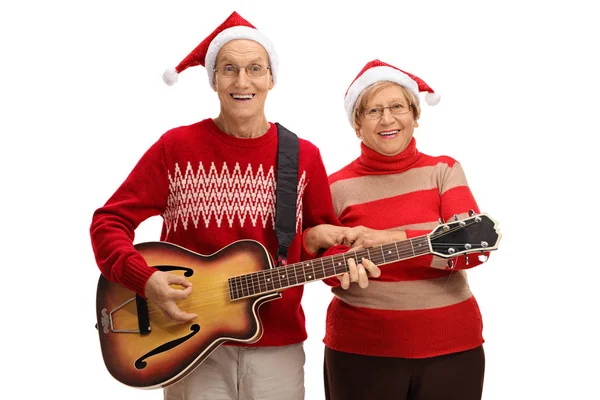 Χαρούμενη ηλικιωμένους με Χριστούγεννα καπέλα παίζοντας κιθάρα — Φωτογραφία Αρχείου