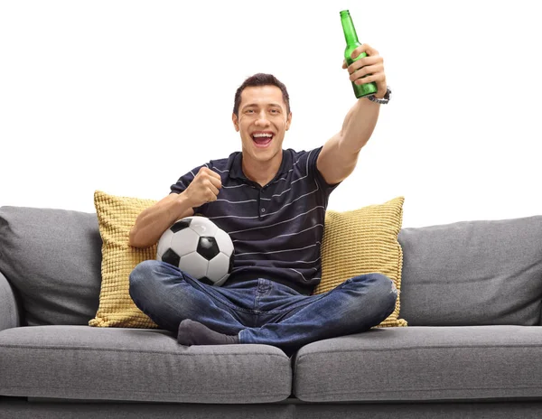 Cara excitado no sofá tomando cerveja e assistindo futebol — Fotografia de Stock