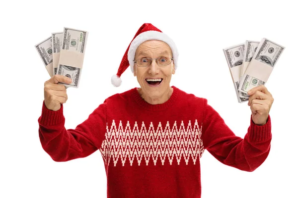 Overjoyed sênior com um chapéu de Natal segurando pacotes de dinheiro — Fotografia de Stock