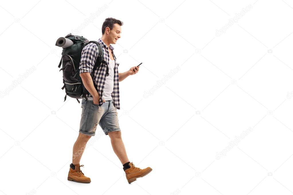 Hiker walking and looking at a mobile phone