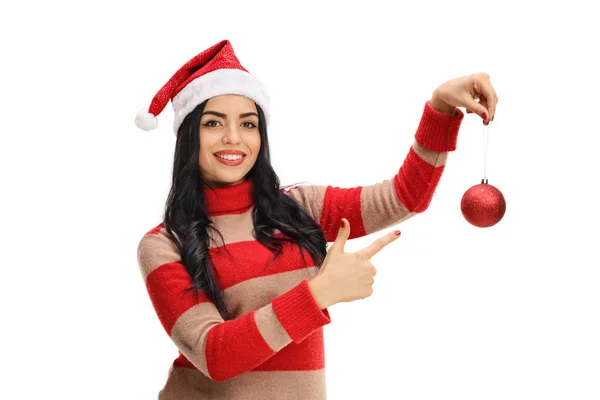 Woman holding christmas ornament and pointing — Stock Photo, Image