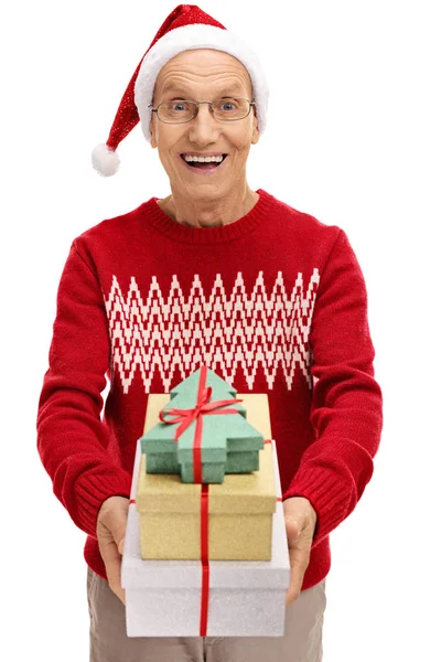 Mann mit Weihnachtsmütze verschenkt Geschenke — Stockfoto