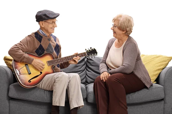 Пожилой мужчина играет на гитаре для пожилой женщины — стоковое фото
