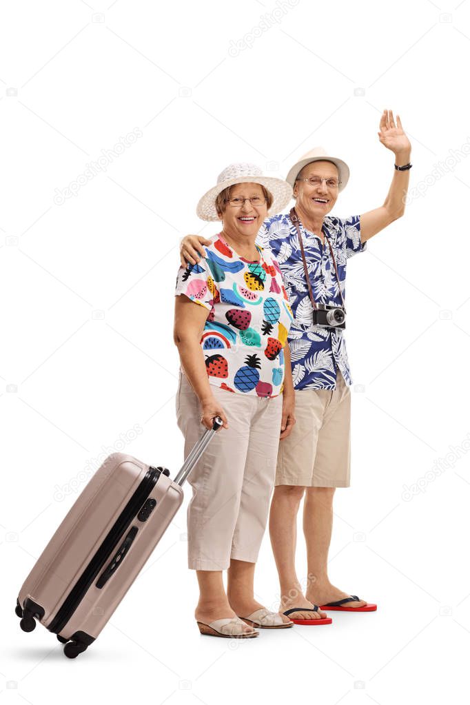 female tourist with suitcase and male tourist waving
