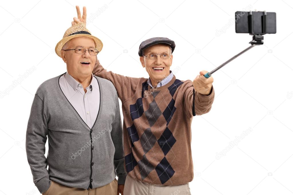 man pranking another man with bunny ears and taking selfie