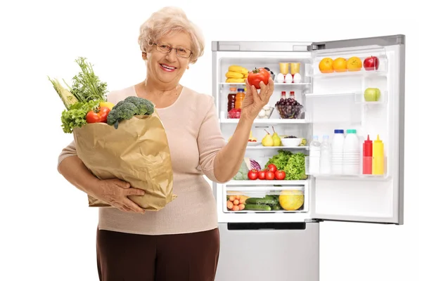 Γυναίκα που κρατά ψώνια τσάντα που γεμίζουν με λαχανικά και ντομάτα — Φωτογραφία Αρχείου