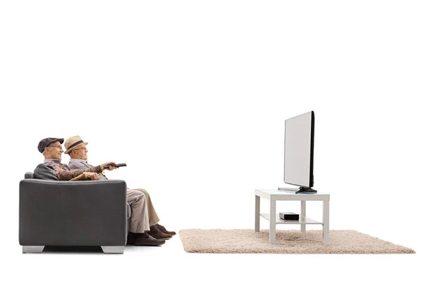 Mogna män sitter på en soffa och titta på TV — Stockfoto